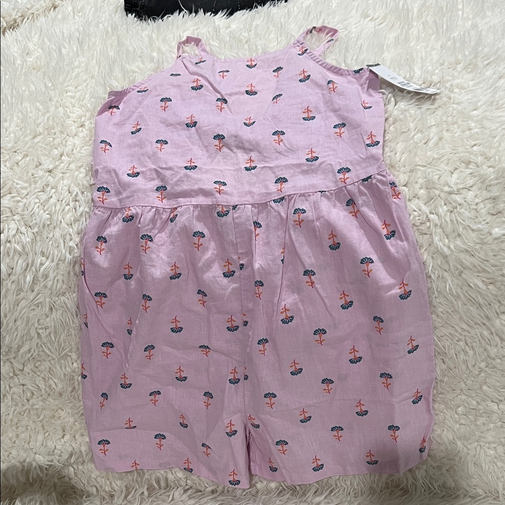Pink Sleeveless Romper with flower Print and knot detail on the back.